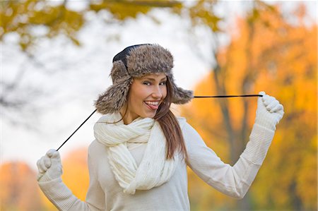 Portrait of a playful beautiful woman in the park in Autumn smiling at camera Stock Photo - Premium Royalty-Free, Code: 6108-08908951