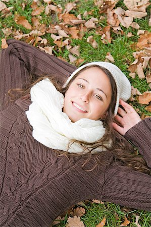 simsearch:6108-08943515,k - Portrait of a content woman lying down in the park smiling at camera Foto de stock - Sin royalties Premium, Código: 6108-08908928