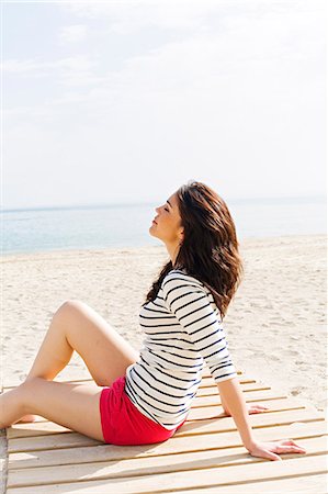 simsearch:6108-08908842,k - Portrait of a beautiful brunette woman sitting at the beach Photographie de stock - Premium Libres de Droits, Code: 6108-08909077