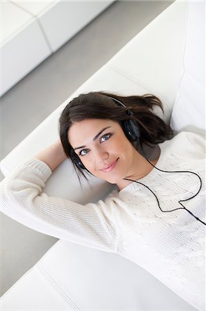 simsearch:6108-05862347,k - Pretty woman with headphones on the sofa Photographie de stock - Premium Libres de Droits, Code: 6108-08909147