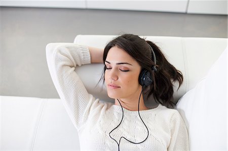 simsearch:640-08089386,k - Pretty woman with headphones on the sofa Stock Photo - Premium Royalty-Free, Code: 6108-08909145