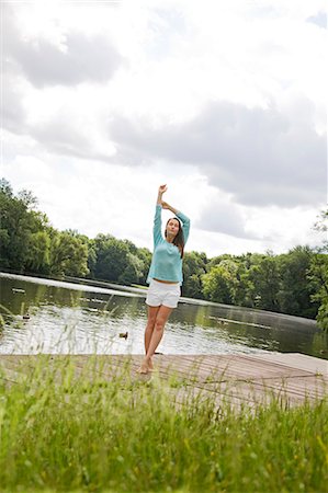 simsearch:6108-08908831,k - Pretty woman stretching by a lake Stock Photo - Premium Royalty-Free, Code: 6108-08909252