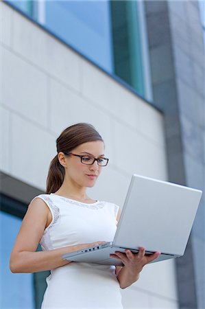 simsearch:6108-08909737,k - Pretty businesswoman with computer in front of a building Stock Photo - Premium Royalty-Free, Code: 6108-08909235