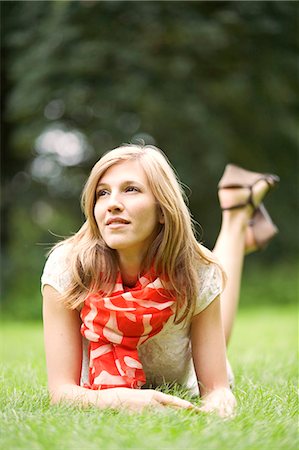 simsearch:6108-08909037,k - Portrait of a blonde woman lying down in the park, smiling and pensive Stock Photo - Premium Royalty-Free, Code: 6108-08909318