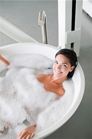 simsearch:6108-08909561,k - Young pretty brunette woman enjoying a bath and smiling at camera Stock Photo - Premium Royalty-Free, Code: 6108-08909593