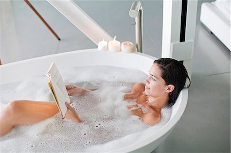 Young pretty brunette woman enjoying a bath and reading a book Stock Photo - Premium Royalty-Free, Code: 6108-08909623