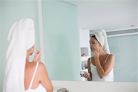 simsearch:6108-08663307,k - Brunette woman applying anti wrinkle cream after the shower Foto de stock - Royalty Free Premium, Número: 6108-08909629