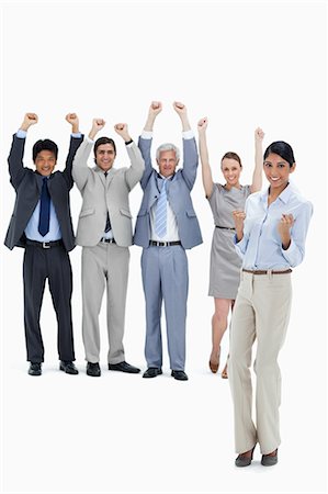 Multicultural business team raising their arms with a woman clenching her fists in foreground against white background Stock Photo - Premium Royalty-Free, Code: 6109-06002640