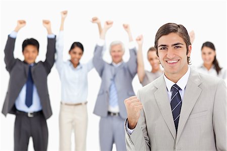 Close-up of a multicultural business team raising their arms focus on a man clenching his fist in foreground Stock Photo - Premium Royalty-Free, Code: 6109-06002670