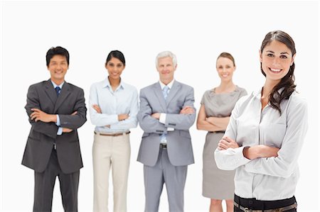 Smiling multicultural business team with their arms folded focus on a woman in foreground Stock Photo - Premium Royalty-Free, Code: 6109-06002679