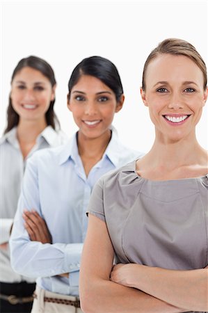 simsearch:6109-06002753,k - Gros plan du sourire des femmes d'affaires en file indienne en mettant l'accent sur la première personne sur fond blanc Photographie de stock - Premium Libres de Droits, Code: 6109-06002743