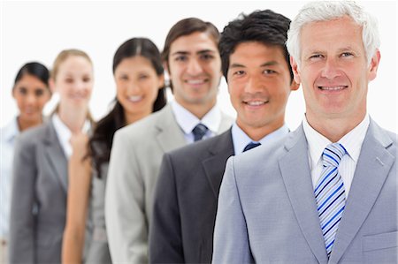 en fila india - Close-up of smiling business people in a single line with focus on the first person against white background Foto de stock - Sin royalties Premium, Código: 6109-06002756