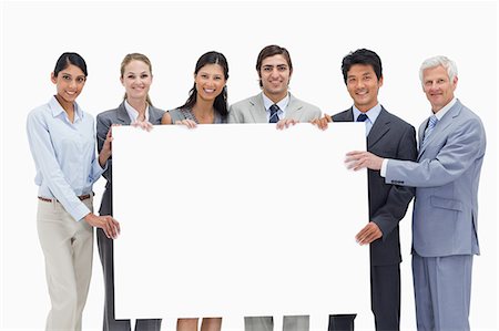 Close-up of a multicultural business team holding a big placard white against white background Stock Photo - Premium Royalty-Free, Code: 6109-06002770