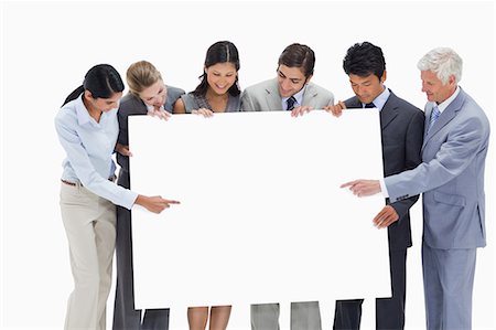 simsearch:6109-06002827,k - Close-up of a multicultural business team holding and showing a big placard white against white background Stock Photo - Premium Royalty-Free, Code: 6109-06002772