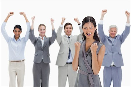 simsearch:6109-06002781,k - Close-up of a smiling woman clenching her fists with a business team raising their arms against white background Foto de stock - Sin royalties Premium, Código: 6109-06002781