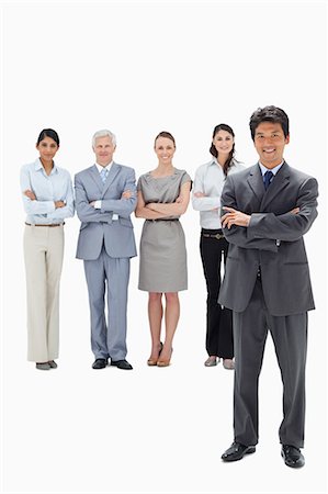 simsearch:6109-06002847,k - Business team with their arms folded and a smiling Asian man in foreground against white background Foto de stock - Royalty Free Premium, Número: 6109-06002701