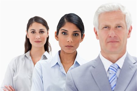 en fila india - Close-up of two young women behind a white hair businessman with focus on the middle woman against white background Foto de stock - Sin royalties Premium, Código: 6109-06002714