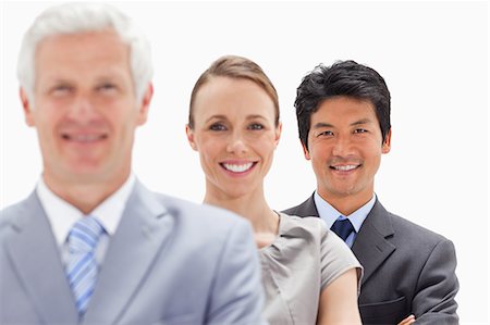 single file - Close-up of two smiling business people behind their boss with focus on the man against white background Foto de stock - Sin royalties Premium, Código: 6109-06002719