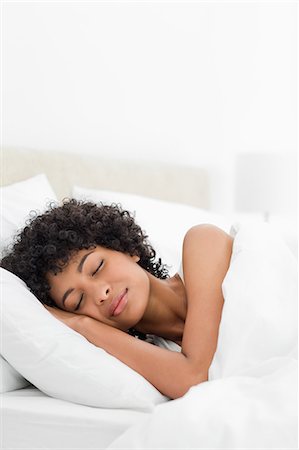 peaceful human - Frizzy haired woman sleeping peacefully in a white bed Stock Photo - Premium Royalty-Free, Code: 6109-06002881