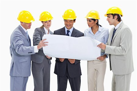 Business people wearing safety helmets looking at a map against white background Foto de stock - Sin royalties Premium, Código: 6109-06002837