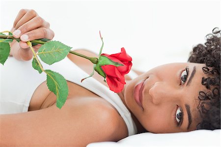 simsearch:6109-06002938,k - Portrait d'une belle femme aux cheveux crépuse, allongée sur son lit avec une rose dans une salle lumineuse Photographie de stock - Premium Libres de Droits, Code: 6109-06002923