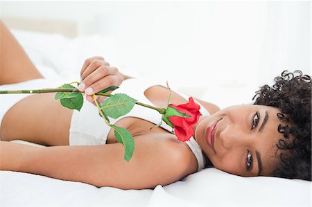 simsearch:6109-06002938,k - Portrait d'une femme crépuse allongée sur son lit avec une rose dans une salle lumineuse Photographie de stock - Premium Libres de Droits, Code: 6109-06002921