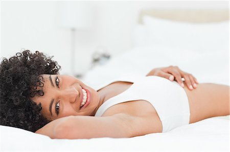 simsearch:6109-06002938,k - Portrait d'une femme souriante métie allongée sur son lit sur fond blanc Photographie de stock - Premium Libres de Droits, Code: 6109-06002933