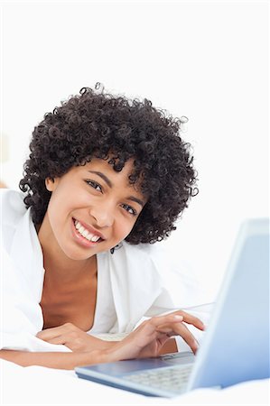 simsearch:6109-06002938,k - Portrait d'une femme souriante, à l'aide d'un ordinateur portable en position couchée sur le ventre Photographie de stock - Premium Libres de Droits, Code: 6109-06003000