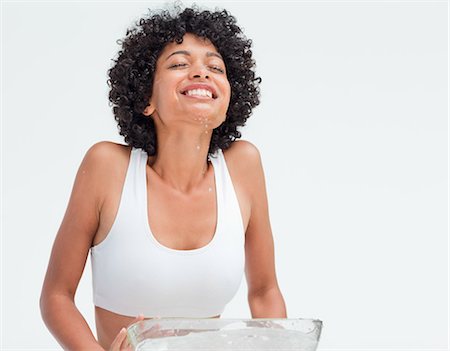 face washing - woman refreshing her face against white background Stock Photo - Premium Royalty-Free, Code: 6109-06003015