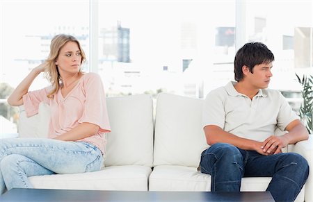 separation anxiety - A man looking angry turned the opposite way to the woman at the other end of the couch looking upset. Stock Photo - Premium Royalty-Free, Code: 6109-06003140