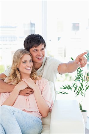 simsearch:6109-06003134,k - A smiling man and woman embrace while they look at something the man is pointing at. Stock Photo - Premium Royalty-Free, Code: 6109-06003164