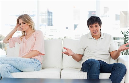 separado - A man is confused as to what has happened as the woman sits turned away and looking upset. Foto de stock - Sin royalties Premium, Código: 6109-06003139