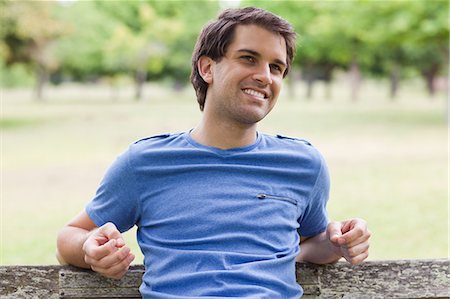 Young smiling man sitting on a bench in the countryside Stock Photo - Premium Royalty-Free, Code: 6109-06003492