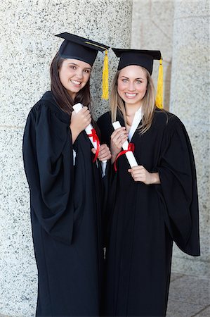 person with cap and gown - Young graduating girls proudly holding their diplomas while showing a great smile Stock Photo - Premium Royalty-Free, Code: 6109-06003572