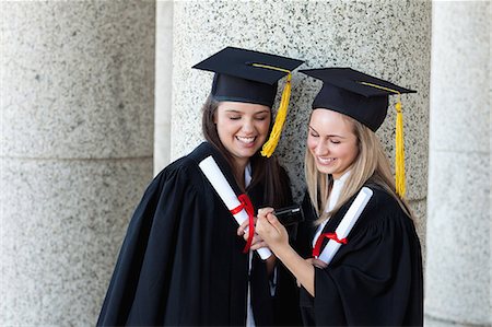 simsearch:6109-06003585,k - Young happy graduating students holding their diplomas while looking at a camera Foto de stock - Royalty Free Premium, Número: 6109-06003577