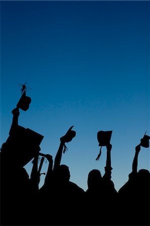 Young graduating students celebrating their new graduation while raising their caps Stock Photo - Premium Royalty-Free, Code: 6109-06003588