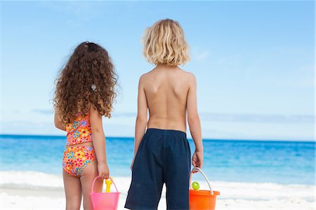 Back view of little children with buckets and shovels on the beach Stock Photo - Premium Royalty-Free, Code: 6109-06003676