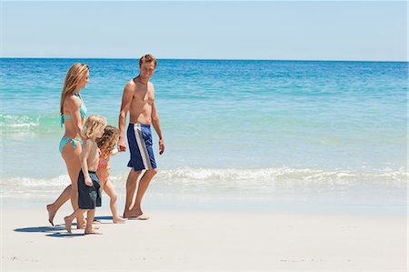 swimsuit family - Side view of a young family taking a walk at the beach Stock Photo - Premium Royalty-Free, Code: 6109-06003765