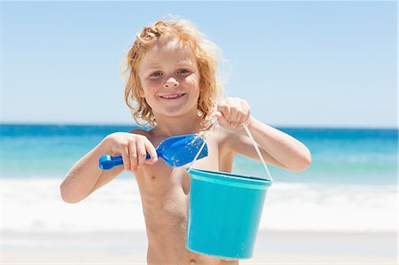 Little boy with a bucket and shovel on the beach Stock Photo - Premium Royalty-Free, Code: 6109-06003777