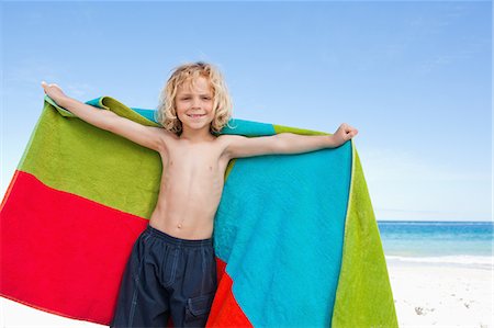 Cute little boy with towel standing on the beach Stock Photo - Premium Royalty-Free, Code: 6109-06003704