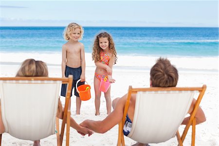 silla de playa - Little children talking with their parents on the beach Foto de stock - Sin royalties Premium, Código: 6109-06003857