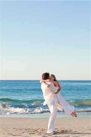 Young man turning his girlfriend on the beach Fotografie stock - Premium Royalty-Free, Codice: 6109-06003828