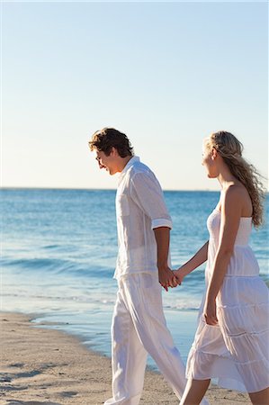 Heureux jeune couple marchant au bord de la mer Photographie de stock - Premium Libres de Droits, Code: 6109-06003833
