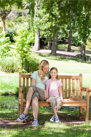 simsearch:6109-06003976,k - A smiling mother looks at her smiling daughter as they both sit on the park bench Foto de stock - Sin royalties Premium, Código: 6109-06003942