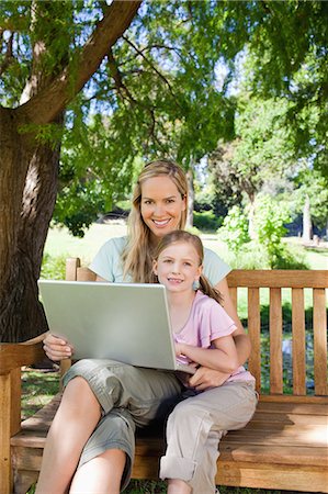 simsearch:6109-06004043,k - A smiling mom and child in the park with a laptop in hand Foto de stock - Sin royalties Premium, Código: 6109-06003956