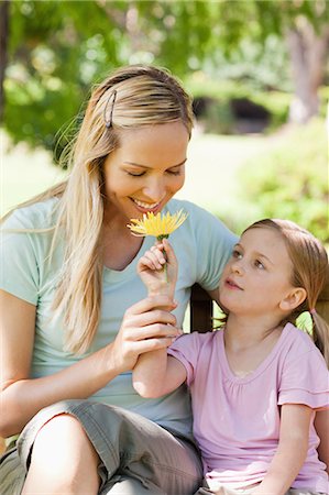 A smiling mother sniffs a flower her daughter is holding to her nose Stock Photo - Premium Royalty-Free, Code: 6109-06003962