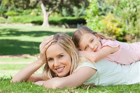 A mother with her daughter rests on her back rests her own head on her hand Stock Photo - Premium Royalty-Free, Code: 6109-06003989