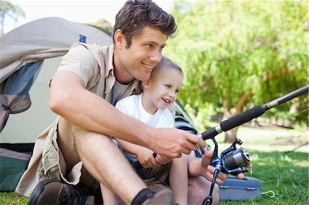 simsearch:6109-06003993,k - A dad shows his son how to fish properly with a rod Foto de stock - Sin royalties Premium, Código: 6109-06003919