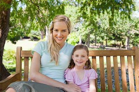 simsearch:6109-06003988,k - A smiling mother and daughter sit together on the bench in the park Stock Photo - Premium Royalty-Free, Code: 6109-06003938