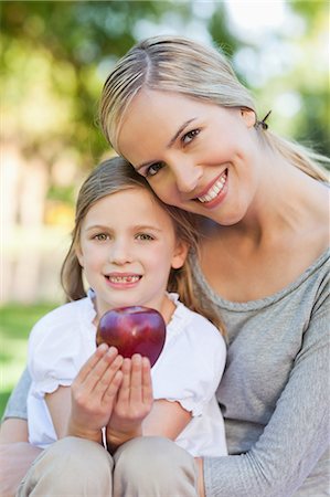 simsearch:6109-06003988,k - A close up shot of a daughter holding an apple while her mother holds her Foto de stock - Sin royalties Premium, Código: 6109-06004054